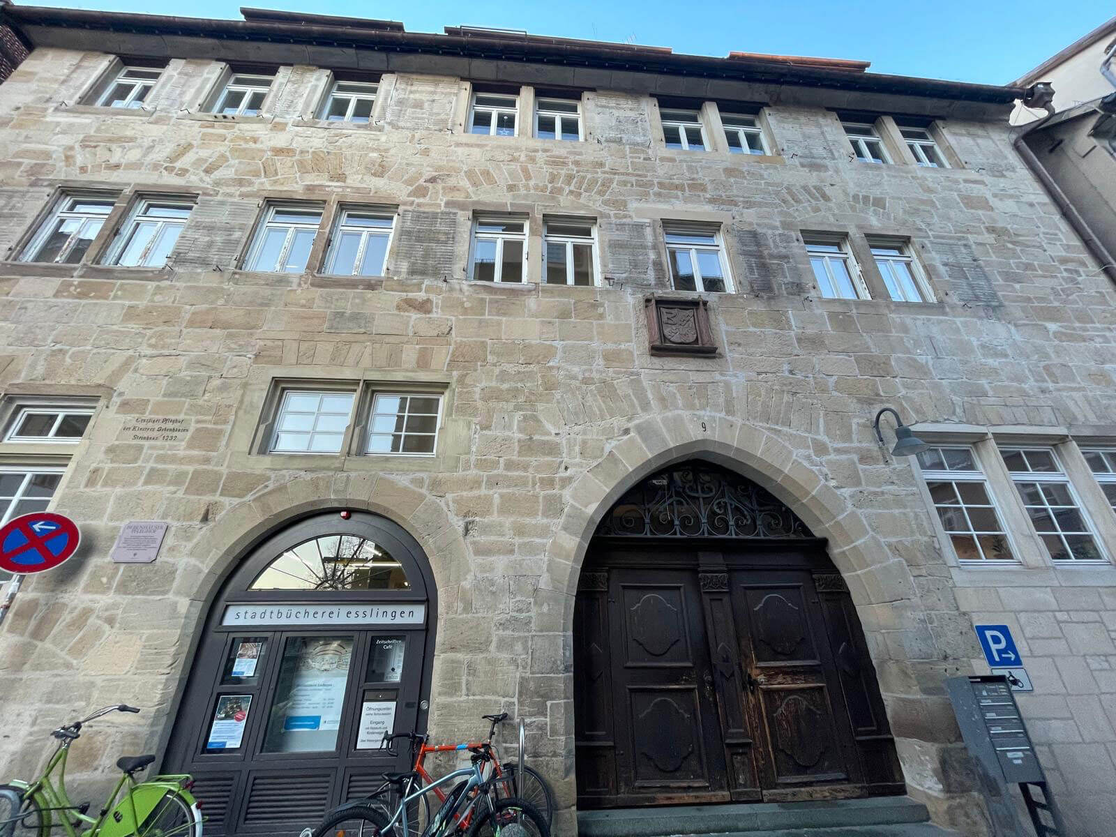 Historischer Haupteingang der Esslingen Pfleghof Stadtbücherei mit gotischem Bogen und Hauptportal.