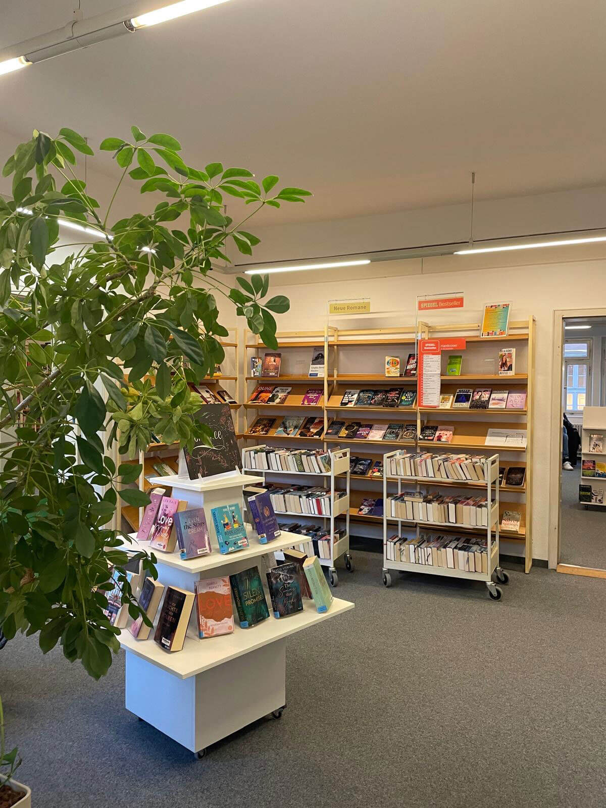 Lesebereich in der Esslingen Pfleghof Stadtbücherei mit aktuellen Romanen, Bücherregalen und Leseinseln – Blick in den bestehenden Bibliotheksstandort.